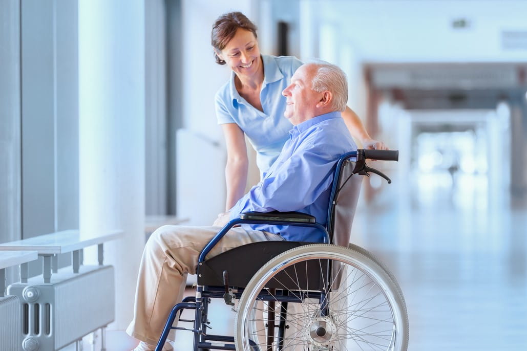 Hospital volunteer assisting man in a wheelchair