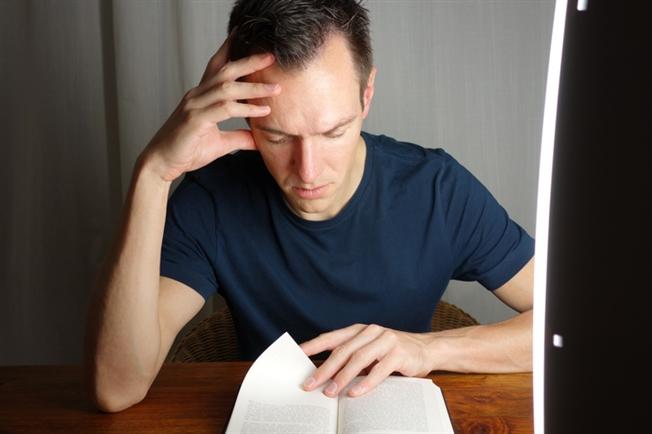 Man reading and using light therapy Man reading and using light therapy