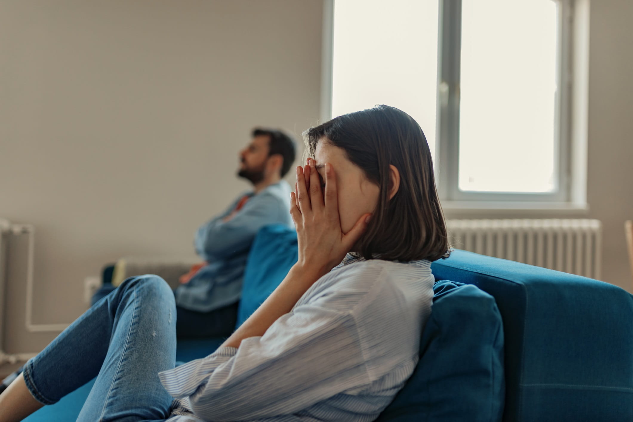 Woman sad head in hands next to boyfriend