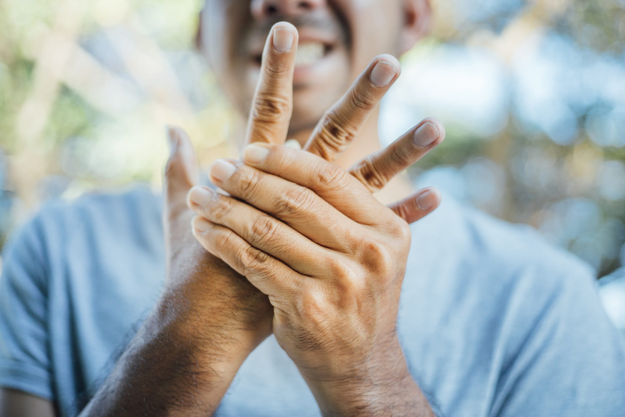 Young man clutching hand in pain