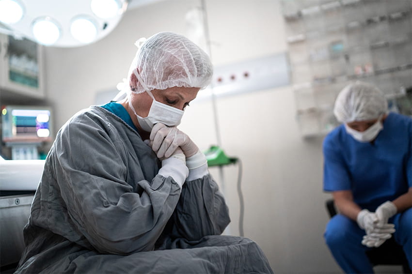 Burnt out physician resting eyes in hospital room