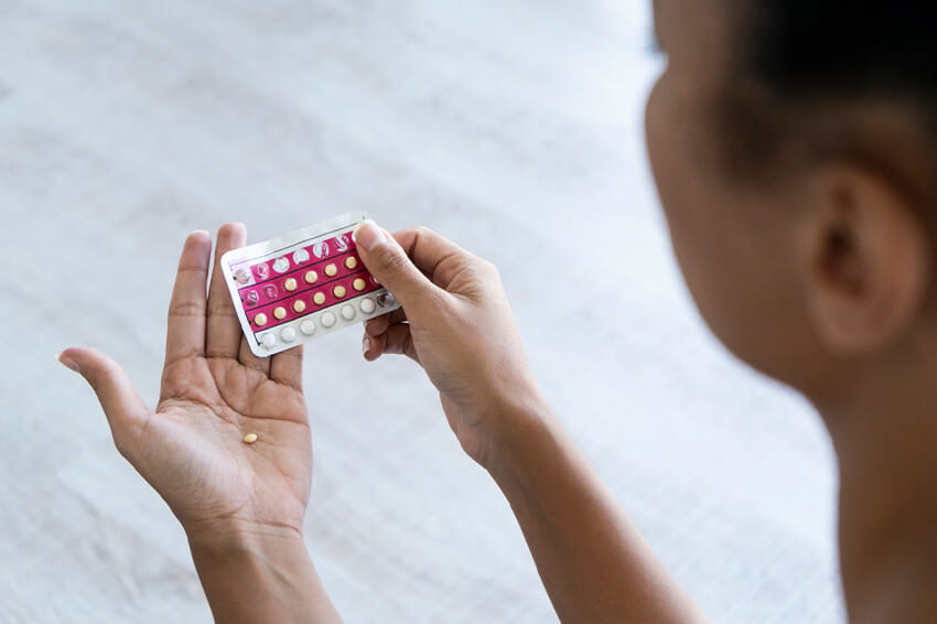 woman holding birth control pills