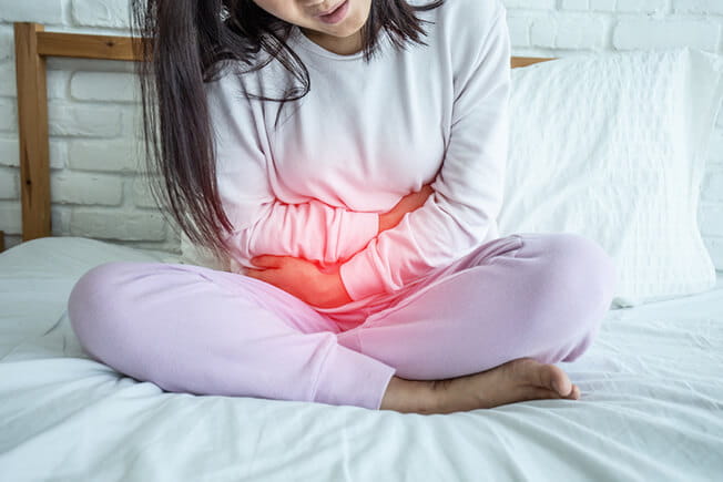 girl holding belly from pelvic floor issues