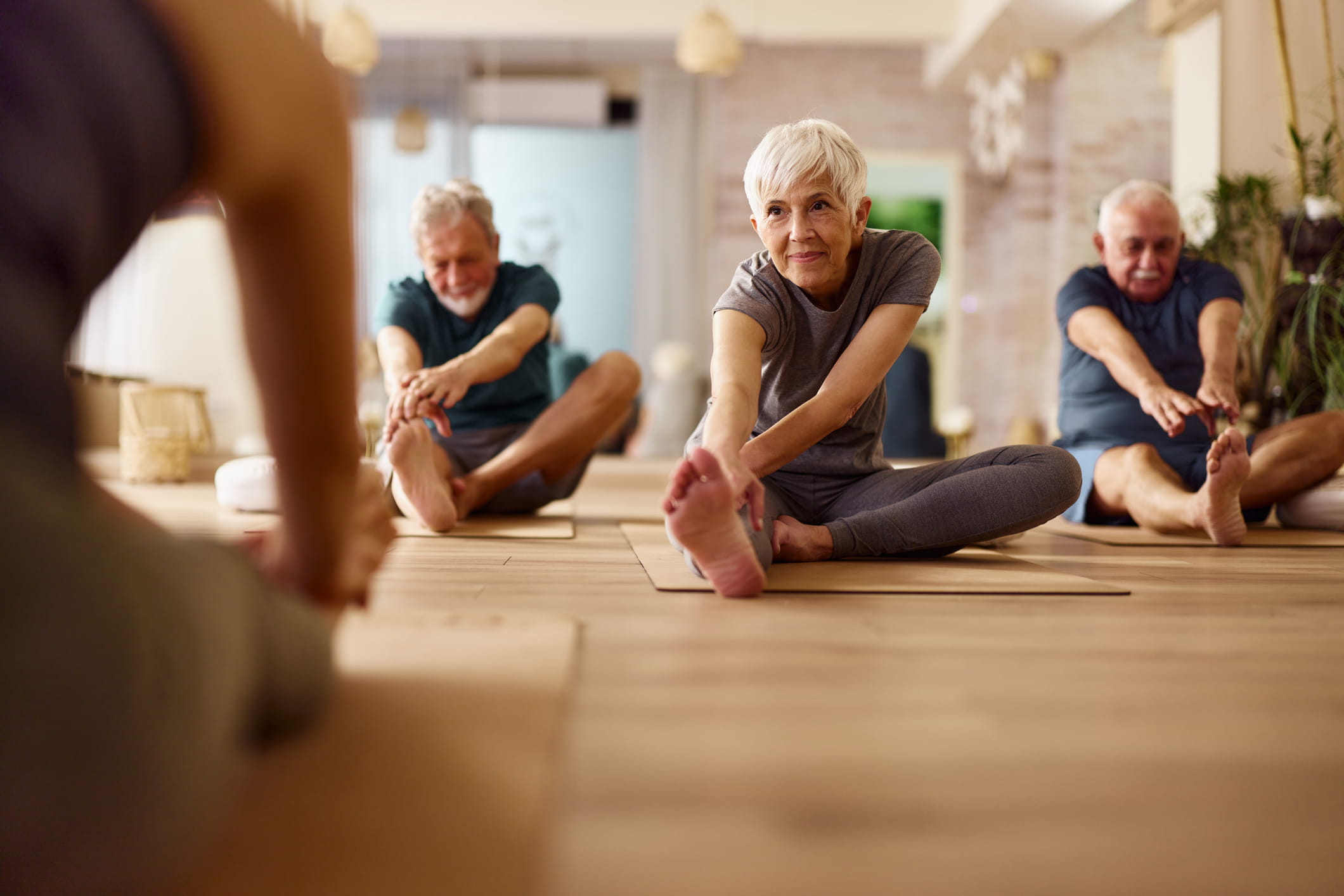 group of older individuals stretching on yoga mats