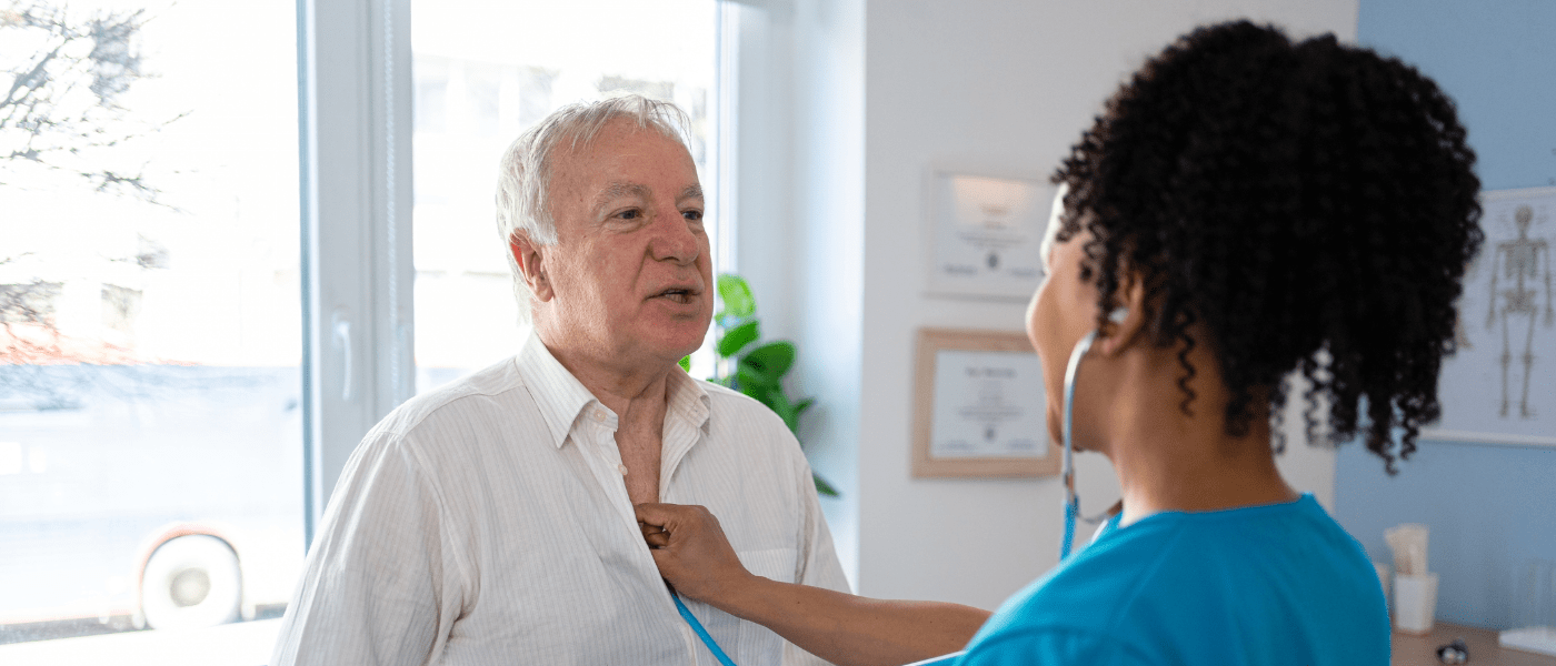 Female nurse examining elderly patient with a stethoscope