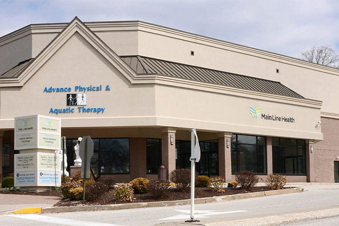 Front of tan building with Main Line Health logo and the words "Advance Physical & Aquatic Therapy" on it. 