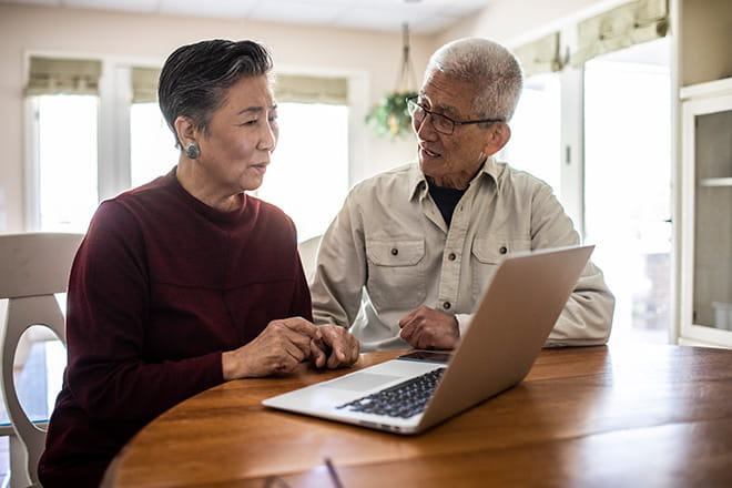 Two family members at home looking at computer