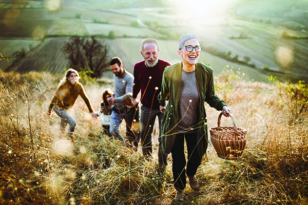 An older couple and their family enjoying a leisurely walk through a picturesque field.