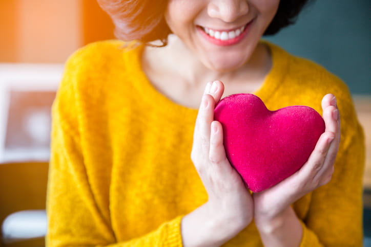Woman holding heart up to chest